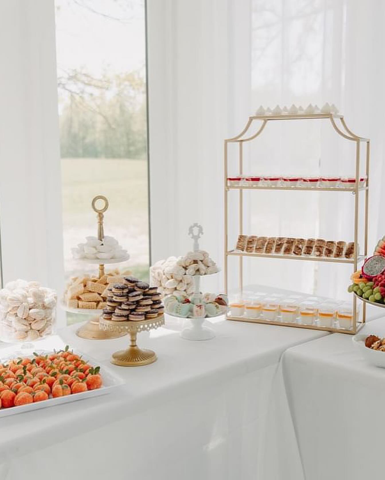 donuts, sweets, and fruits on a table with white cloth.