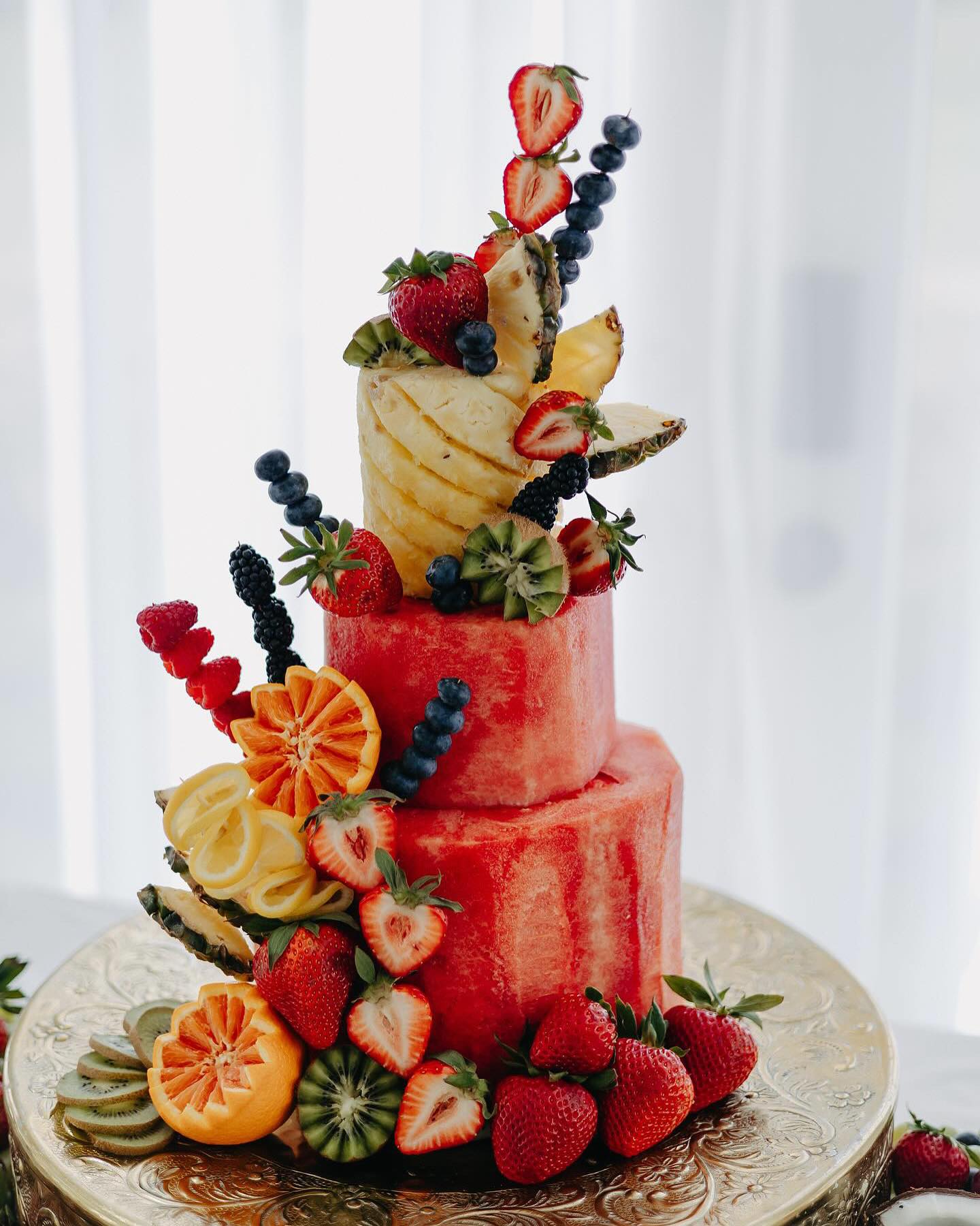 fruit cake made out of watermelon, pineapple, strawberries, and blueberries