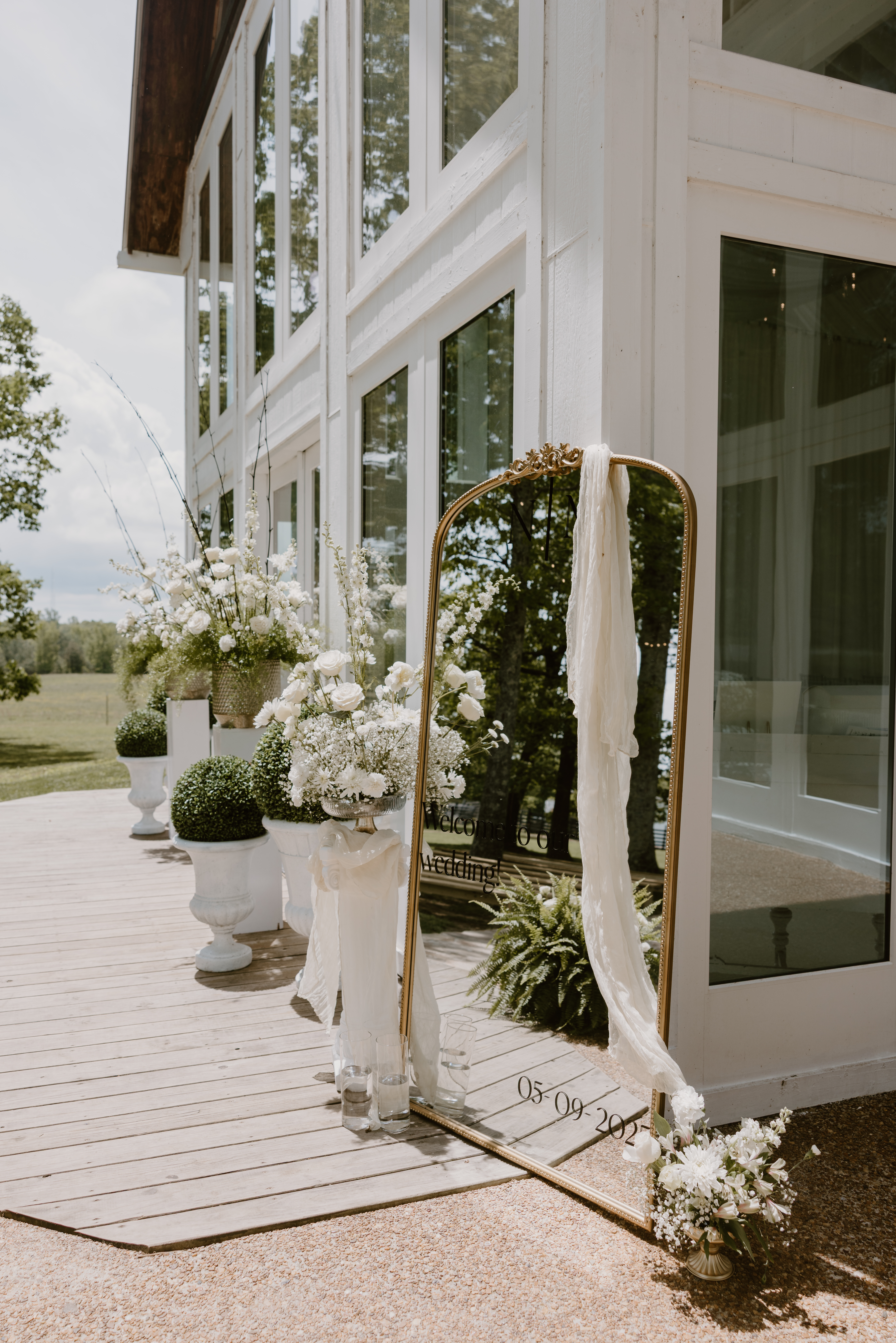 mirror with wedding date on it surrounded by flowers.